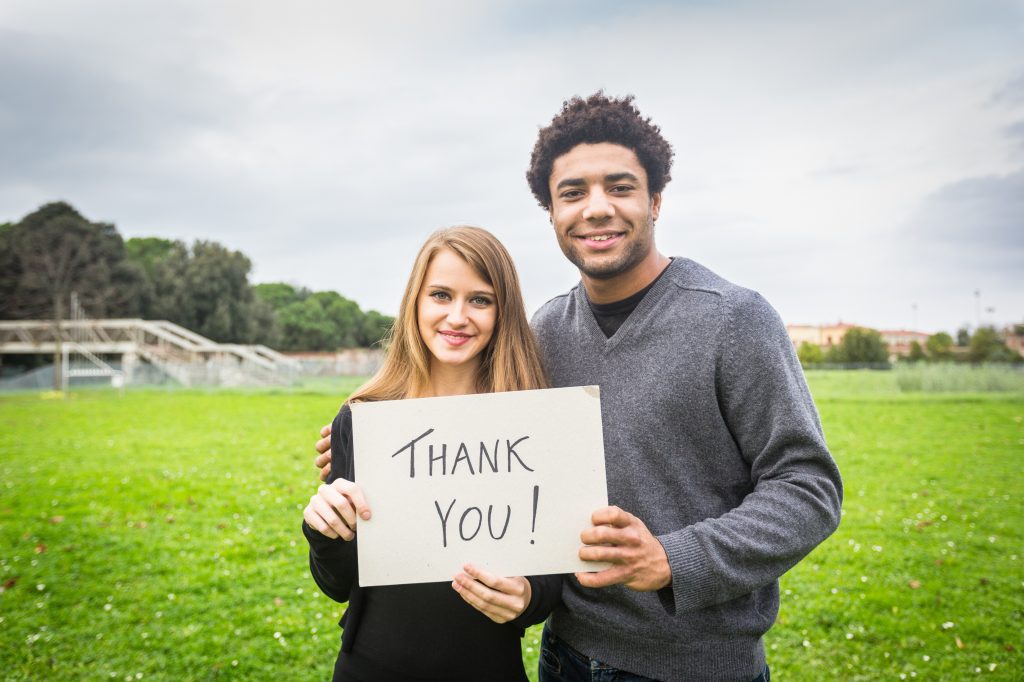A Couple Holding a Thank You Card
